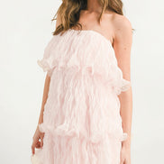 Vestido corto strapless rosa de olanes de perfil