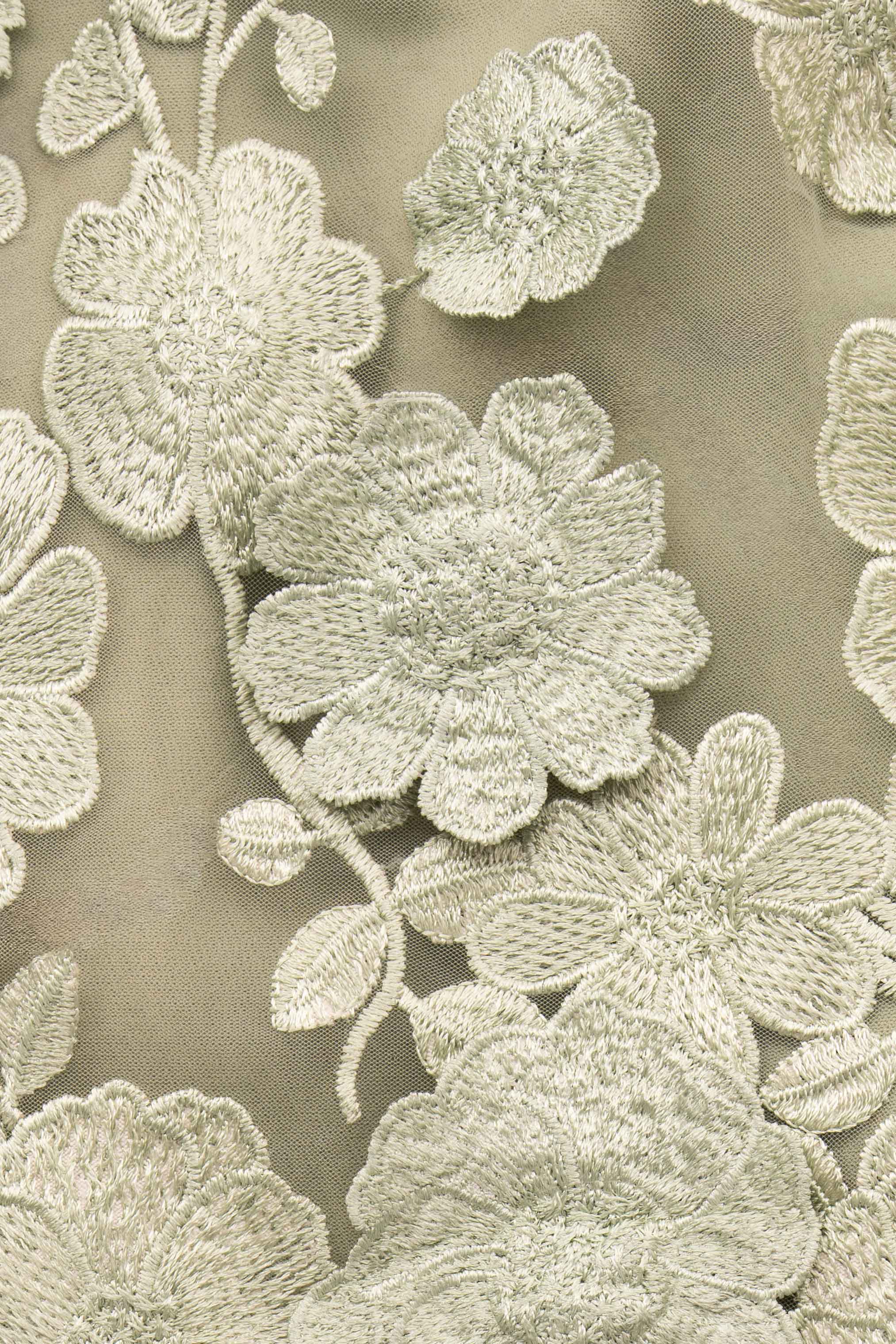 Detalle del bordado floral verde salvia del vestido